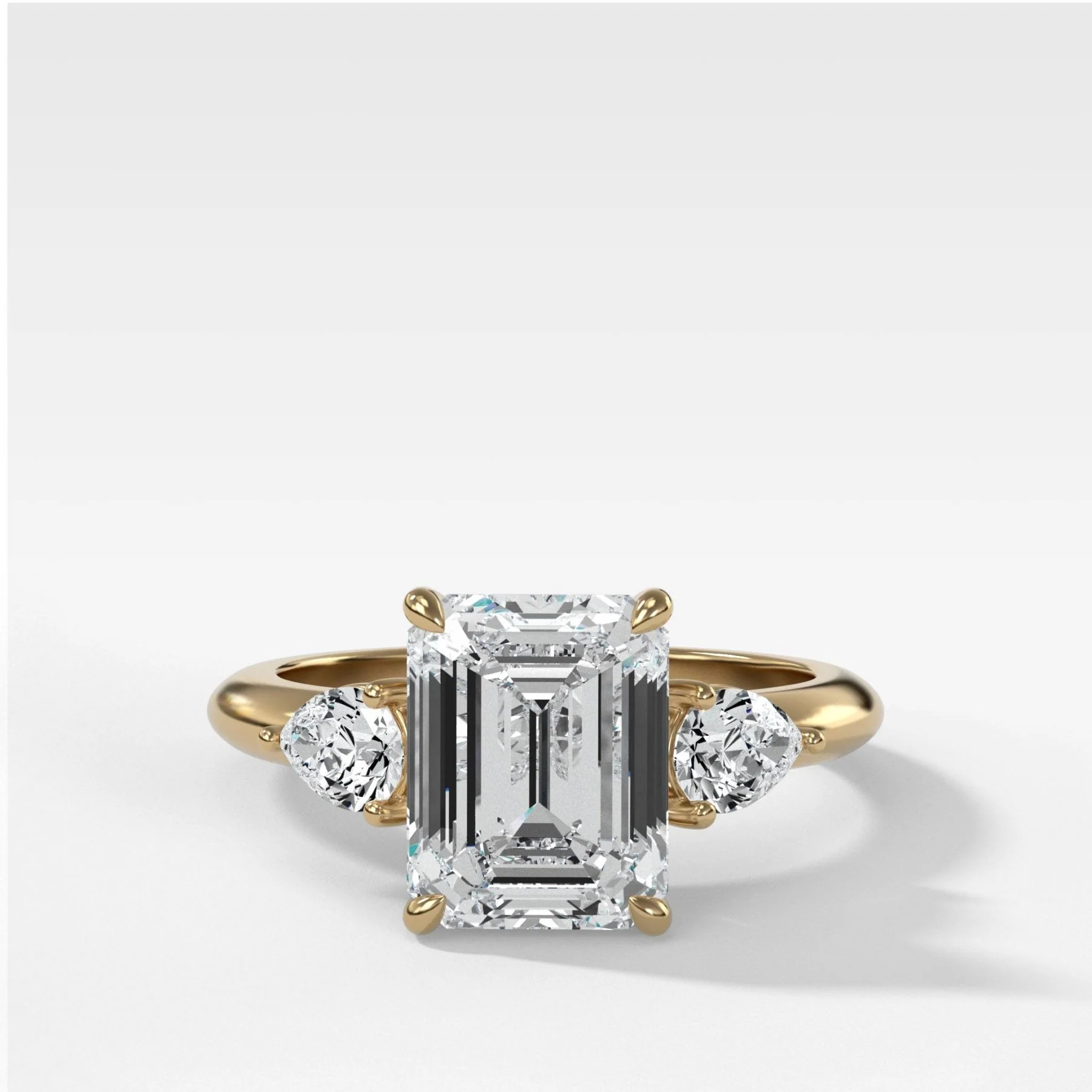 Three Stone Engagement Ring With Pear Side Stones and Emerald Cut Diamond